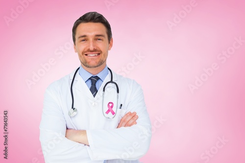 Composite image of handsome young doctor with arms crossed