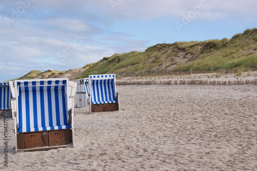 Leere Strandkörbe mit Dünen
