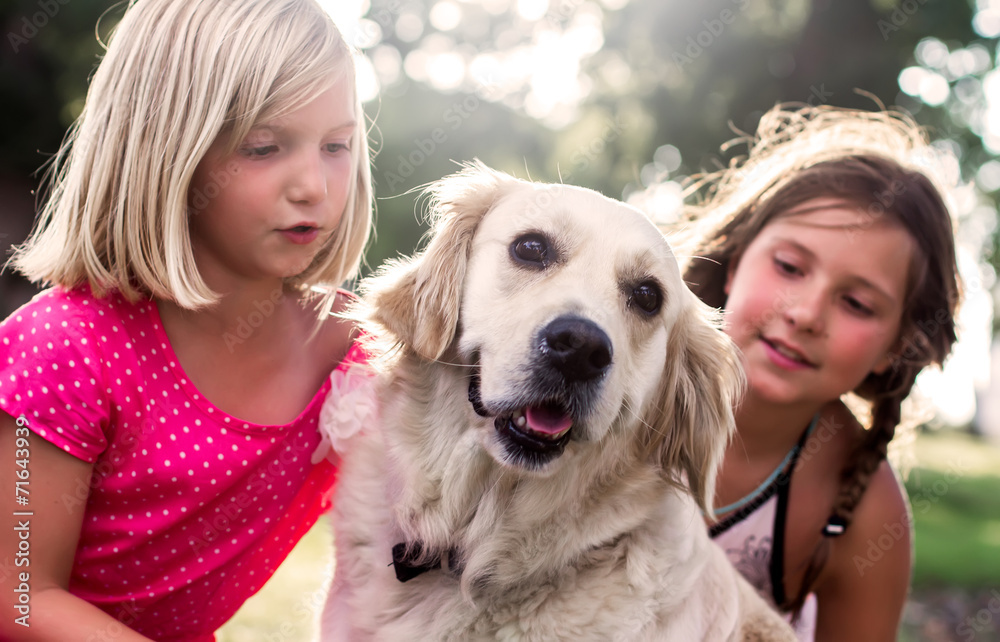Two little girls with golden retriever dog