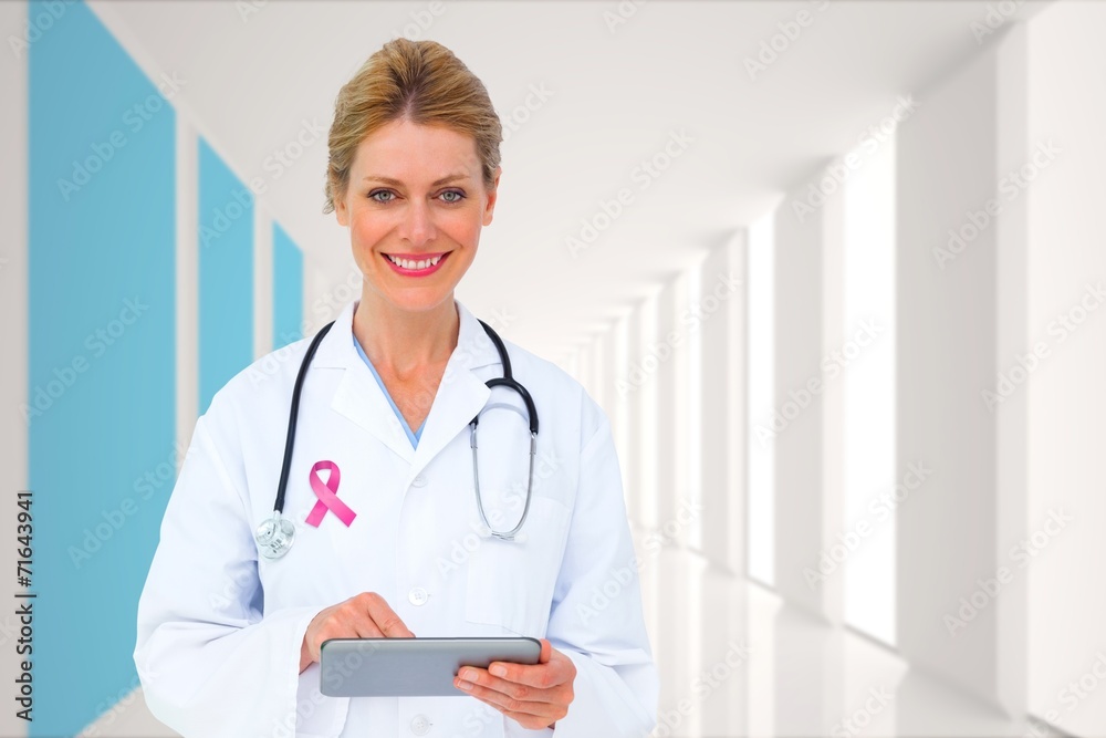 Composite image of blonde doctor using tablet pc Composite image of blonde doctor using tablet pc