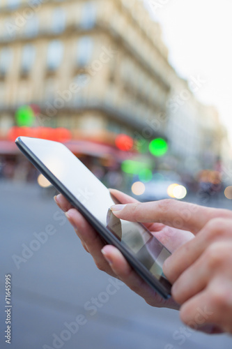 Woman using her cell phone on the street in Paris