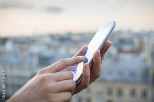 Woman using her mobile phone , city skyline background