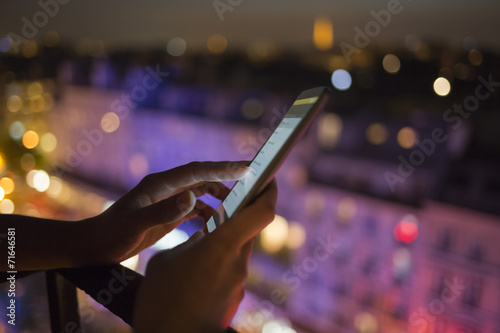 Woman using her mobile phone , city skyline night light