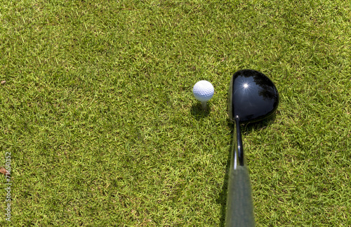 Top view of golf driver and ball on tee
