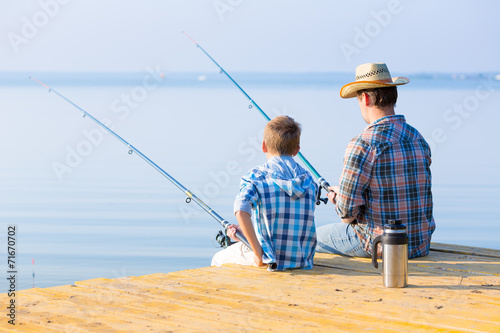 boy and his father fishing togethe