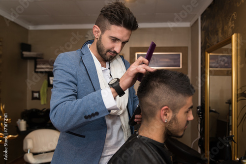 Hairdresser Making Haircut To Young Man