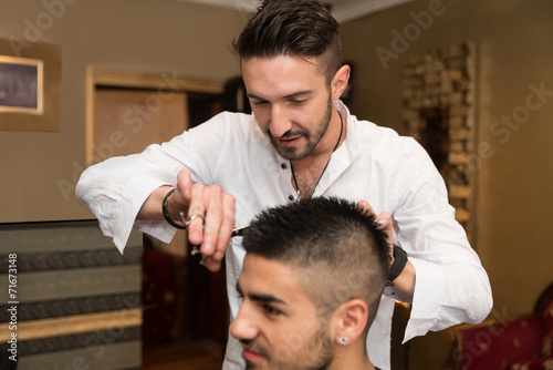 Hairdresser Making Haircut To Young Man