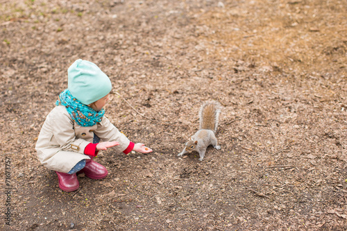 Little girl feeds a squirrel in Central park, New York, America