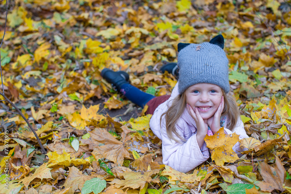 Adorable little girl outdoors at beautiful warm autumn day