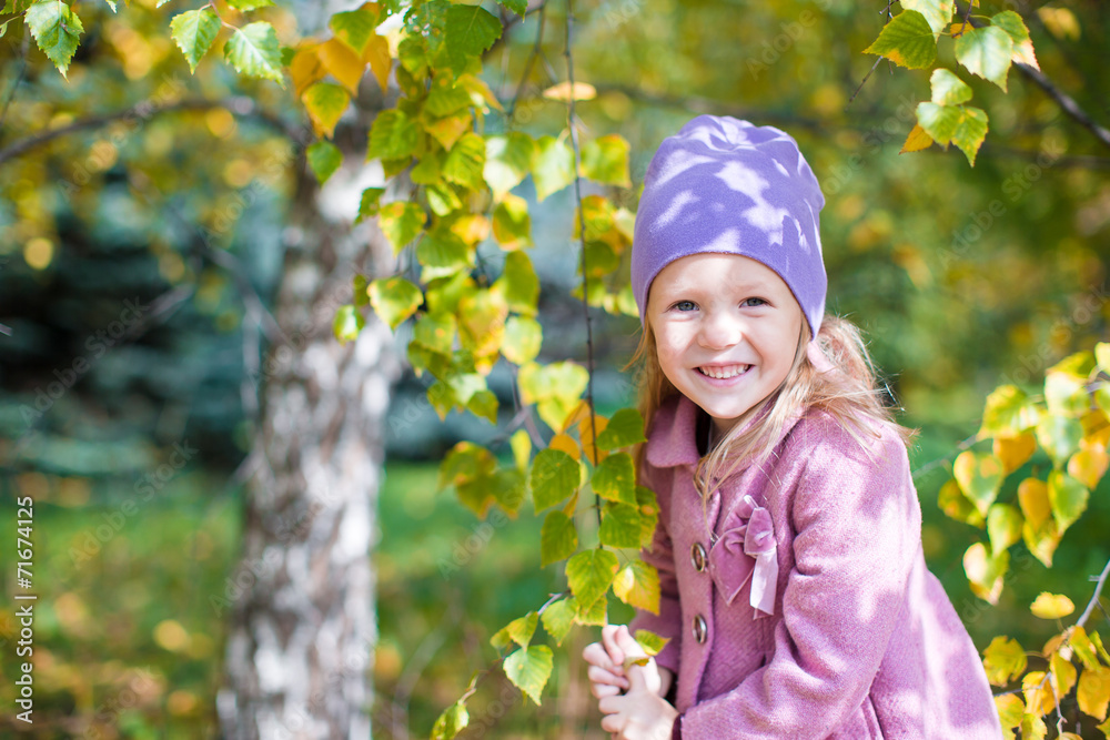 Adorable little girl at beautiful autumn day outdoors