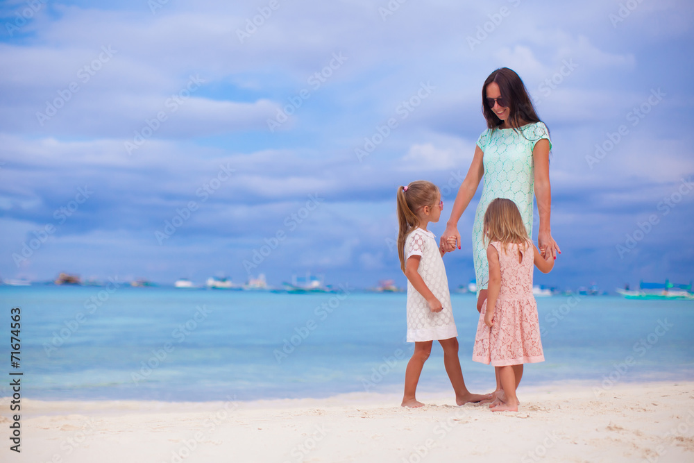 Beautiful mother and her little daughters at exotic beach Beautiful mother and her little daughters at exotic beach