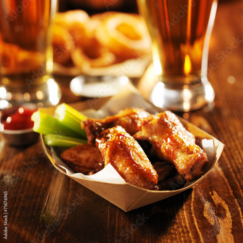barbecue buffalo chicken wings served with beer, celery,