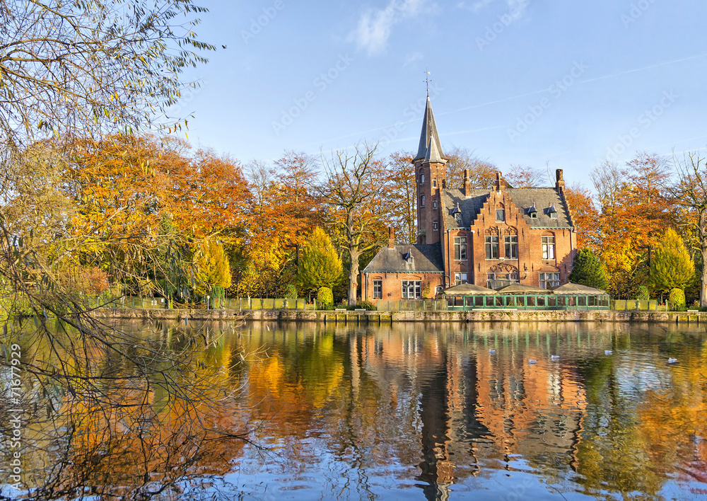 Fototapeta premium Budynek w stylu flamandzkim odzwierciedlający jezioro Minnewater, Brugia, Belgia