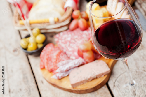 Glass of red wine with charcuterie assortment on the background