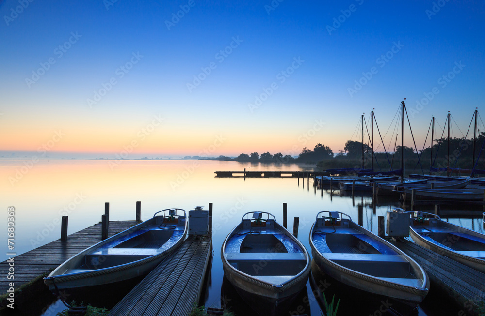 Tranquil sunrise at a small marina on a lake.