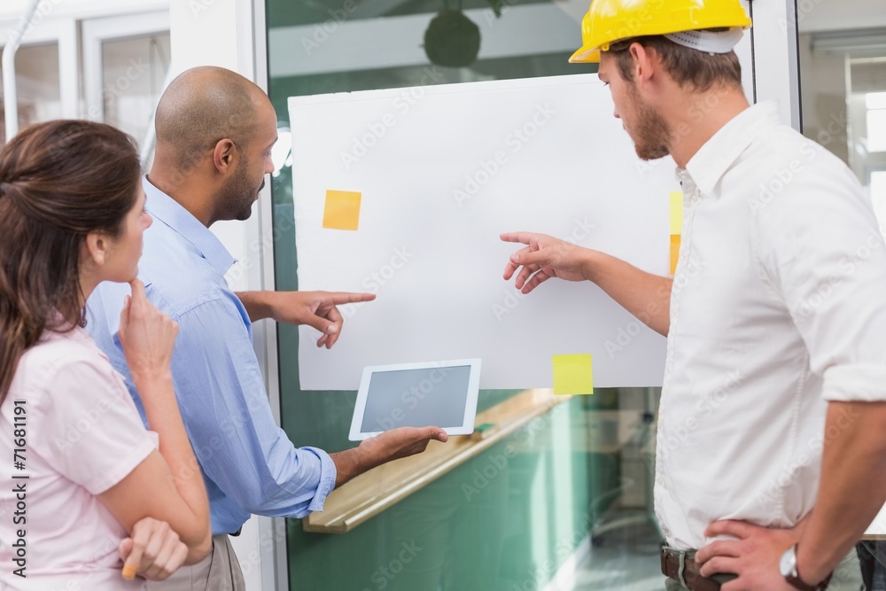 Obraz premium Architect team brainstorming together using digital tablet