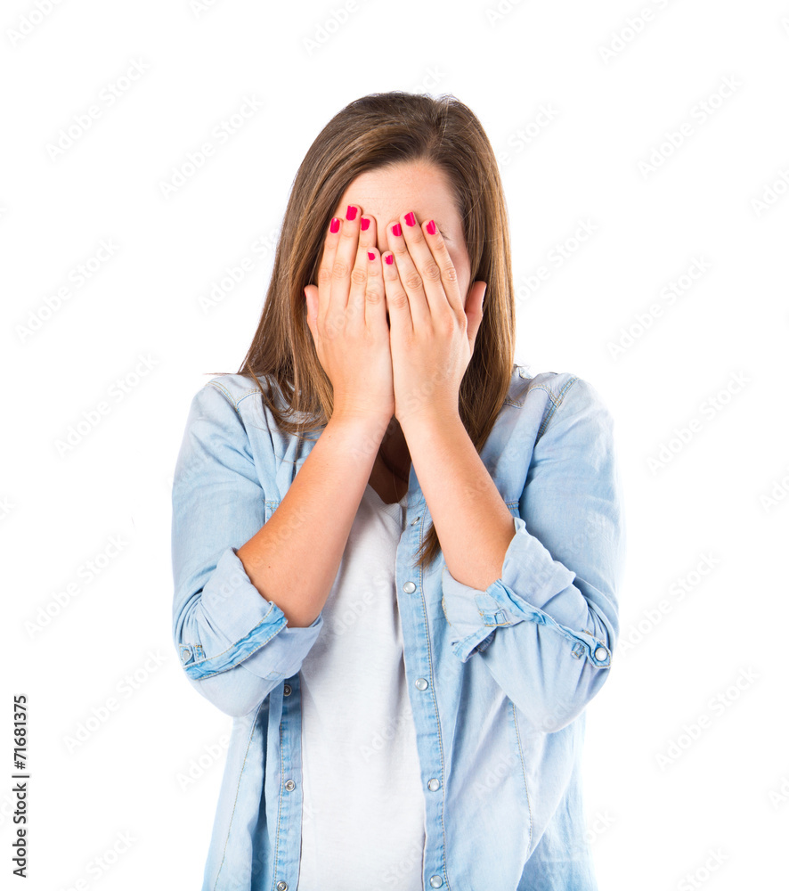 Girl covering her eyes over isolated white background Girl covering her eyes over isolated white background