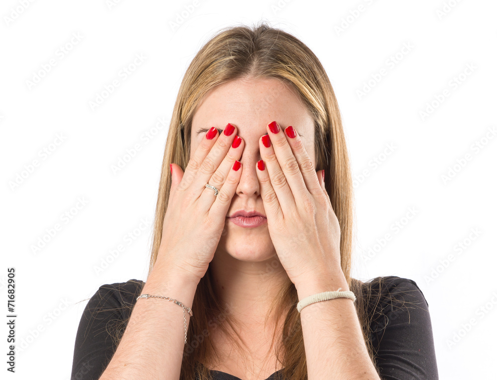 Girl covering her eyes over isolated white background Girl covering her eyes over isolated white background