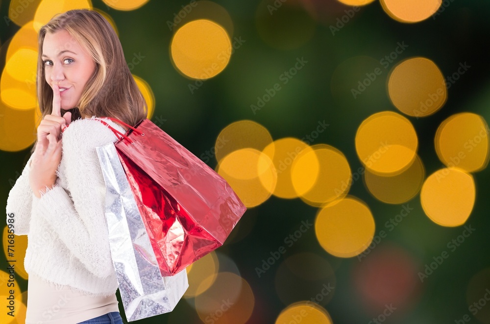 Composite image of pretty blonde keeping a secret holding bags Composite image of pretty blonde keeping a secret holding bags