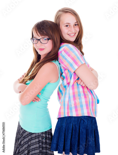 Portrait of two teen girls standing back-to-back