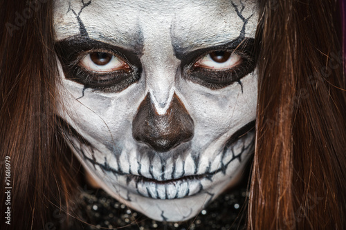 Young woman in day of the dead mask skull face art.