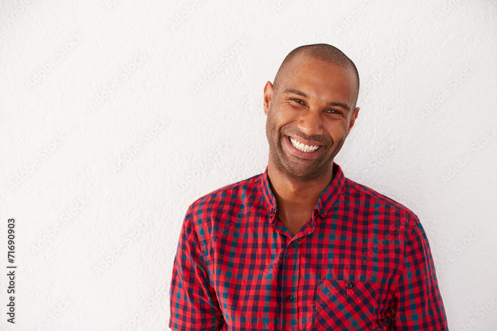 Portrait Of Casually Dressed Man Leaning Against White Wall