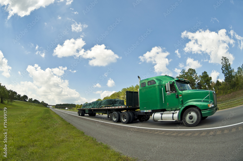 Green Semi Truck Speeds Down Highway