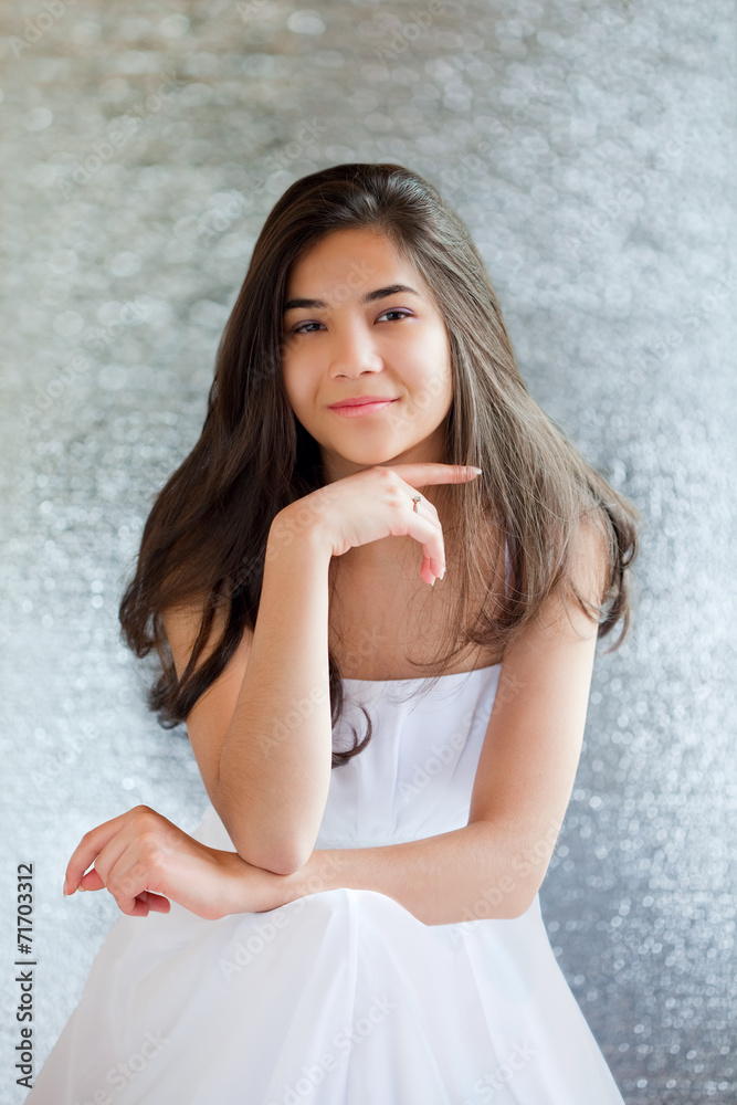 Beautiful biracial teen girl in white dress sitting, thinking Beautiful biracial teen girl in white dress sitting, thinking