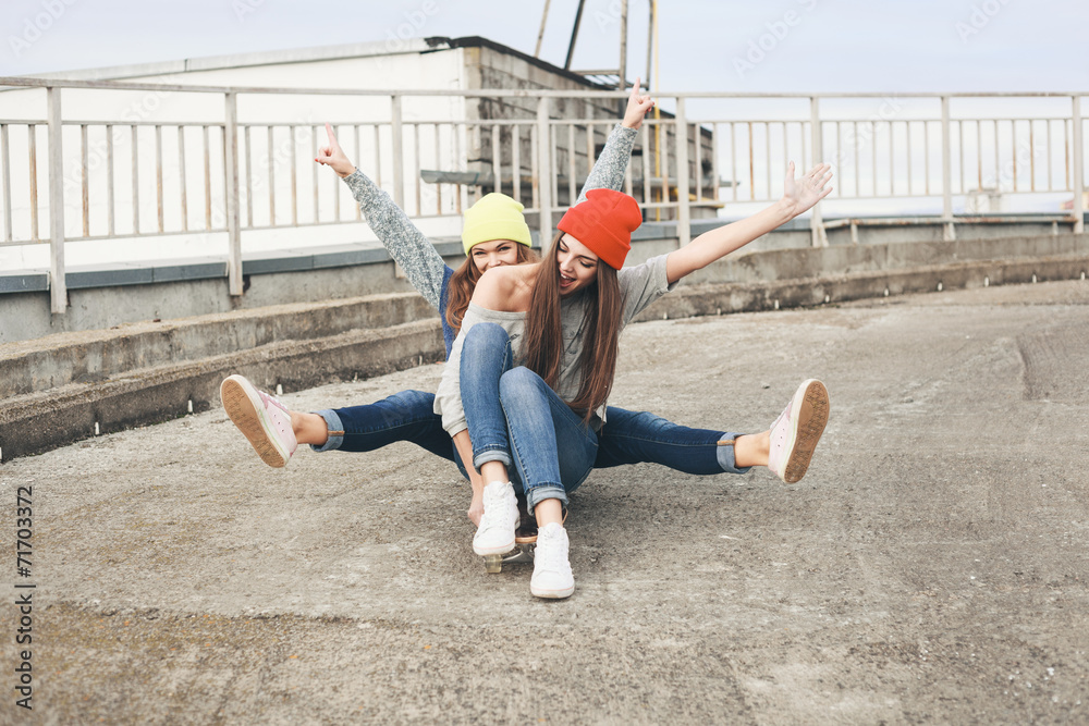 Two young  longboarding girl friends