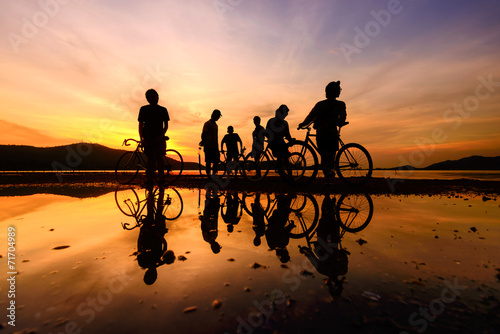 Silhouette cyclists with reflection