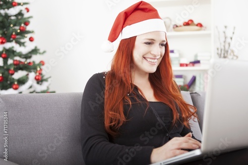 girl with santa hat is shopping online