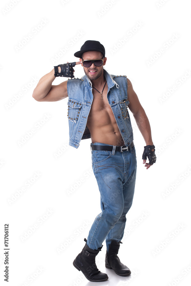 Cheerful muscular male model posing in denim suit Cheerful muscular male model posing in denim suit