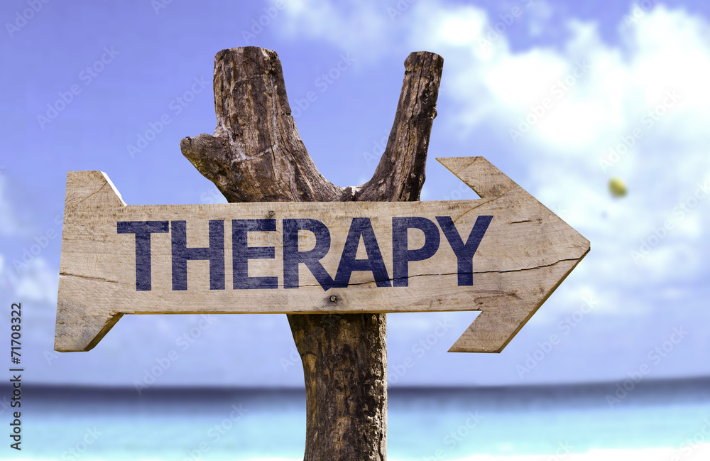 Therapy wooden sign on a beach background