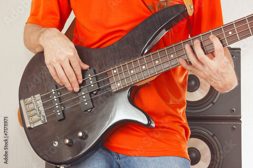 Bass guitarist playing the electric bass guitar closeup