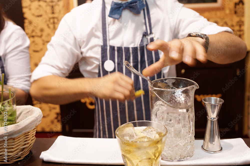 Bartender is making cocktail at bar counter, toned Bartender is making cocktail at bar counter, toned