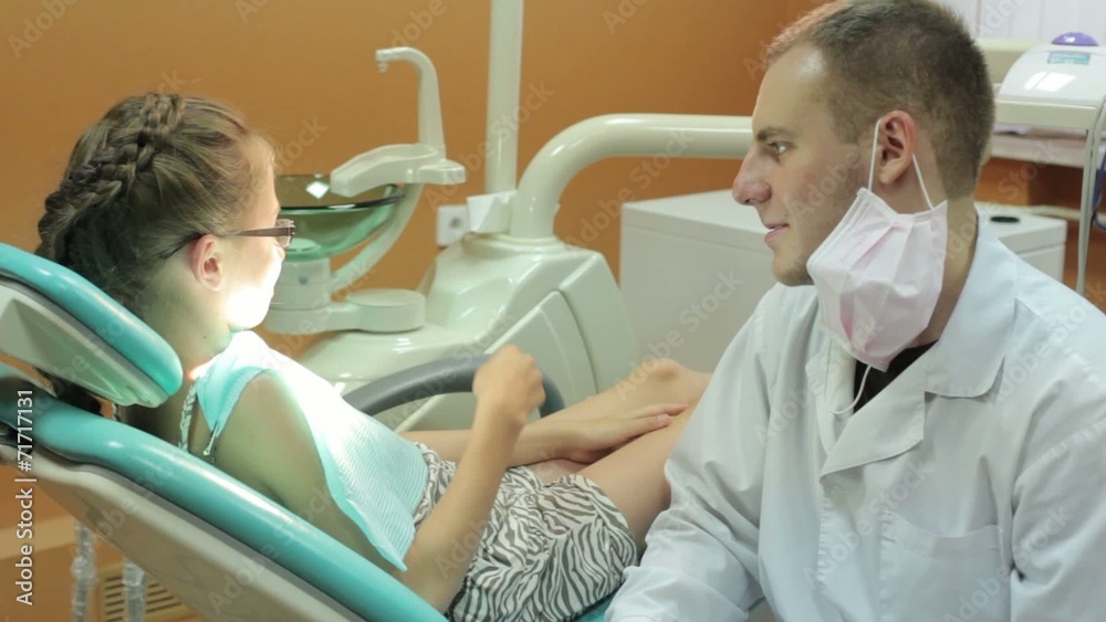 Dentist talking to a little girl before treatment Dentist talking to a little girl before treatment