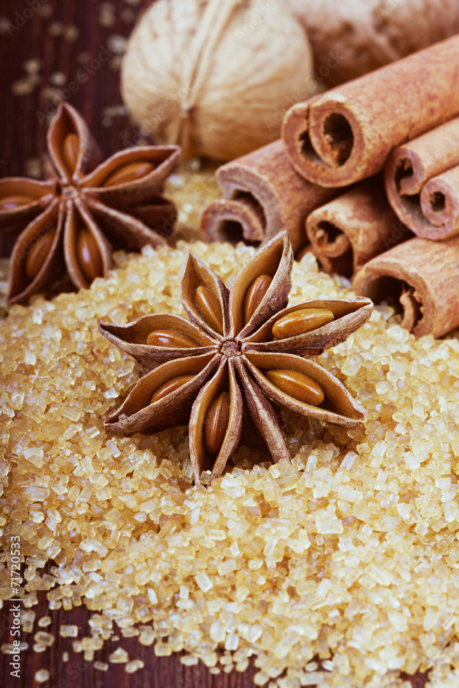 Anise star with cinnamon sticks and walnuts on brown cane sugar Anise star with cinnamon sticks and walnuts on brown cane sugar