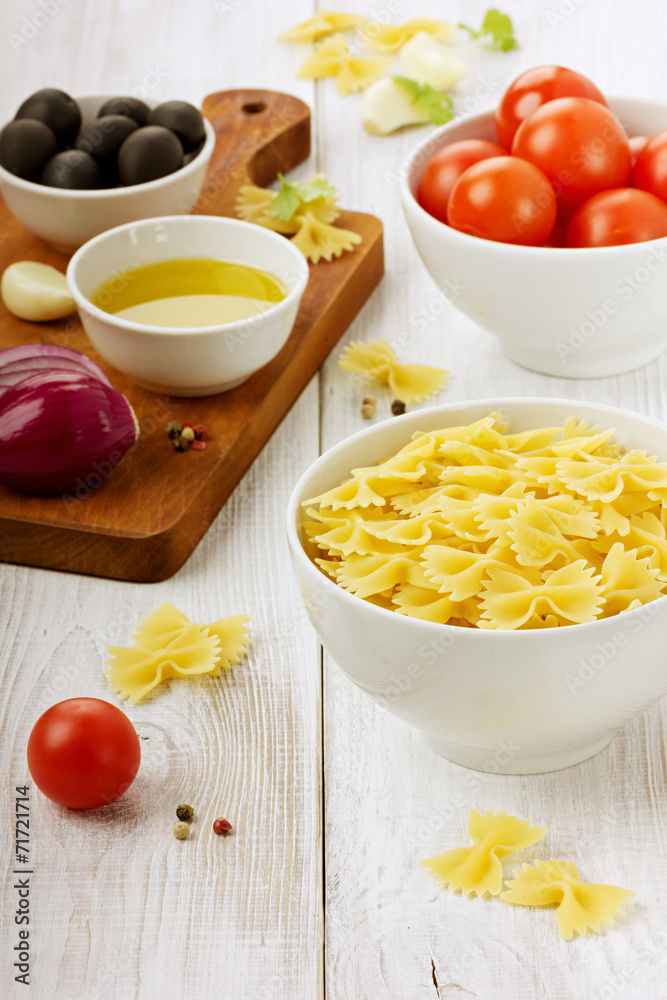 Pasta farfalle before preparation on a wooden background Pasta farfalle before preparation on a wooden background
