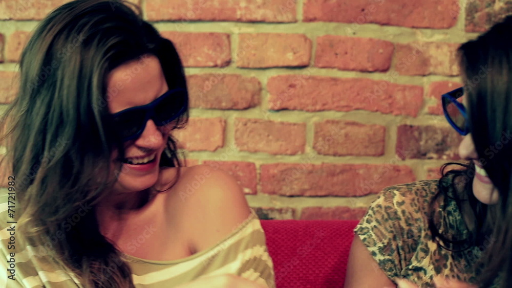 Women laughing while watching movie in 3d glasses Women laughing while watching movie in 3d glasses