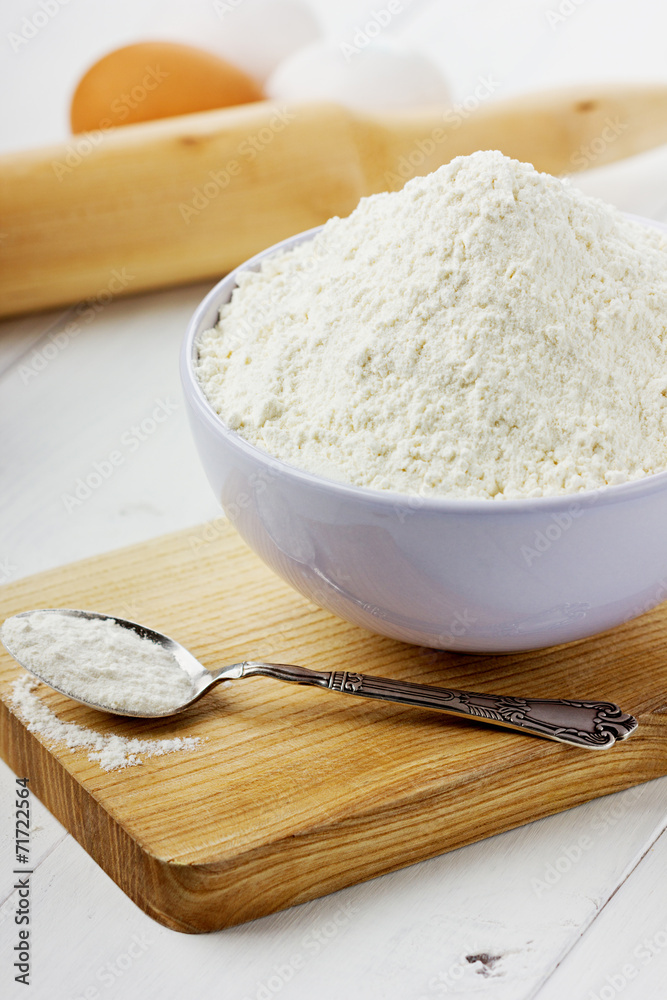 Flour in ceramic bowl with eggs and rolling pin Flour in ceramic bowl with eggs and rolling pin