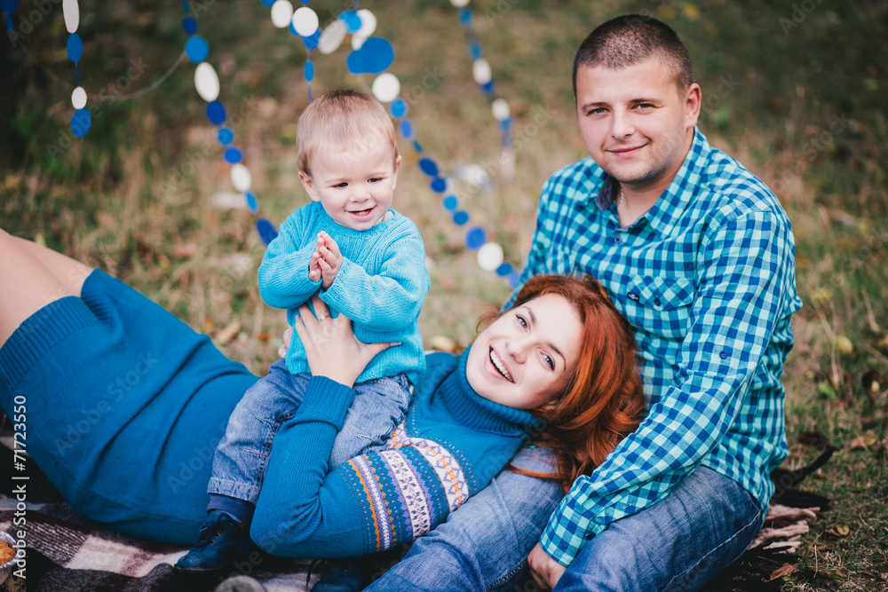 Naklejka premium Happy family have birthday party with blue decorations in forest