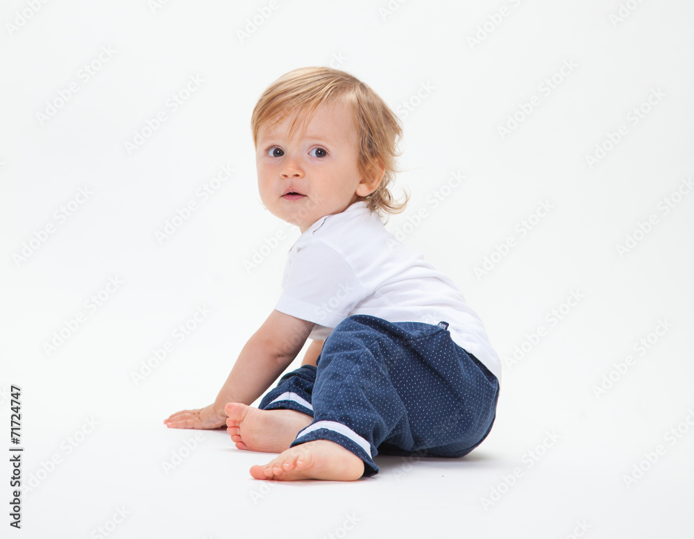 Kleiner Blonder Junge sitzt und schaut Kleiner Blonder Junge sitzt und schaut