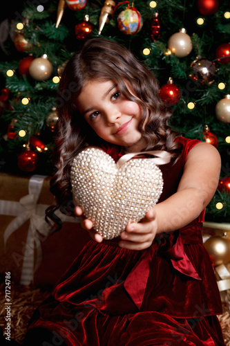 Beautiful young girl showing a heart