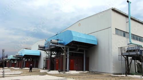 engineer goes near turbo pumping units on gas compressor station photo