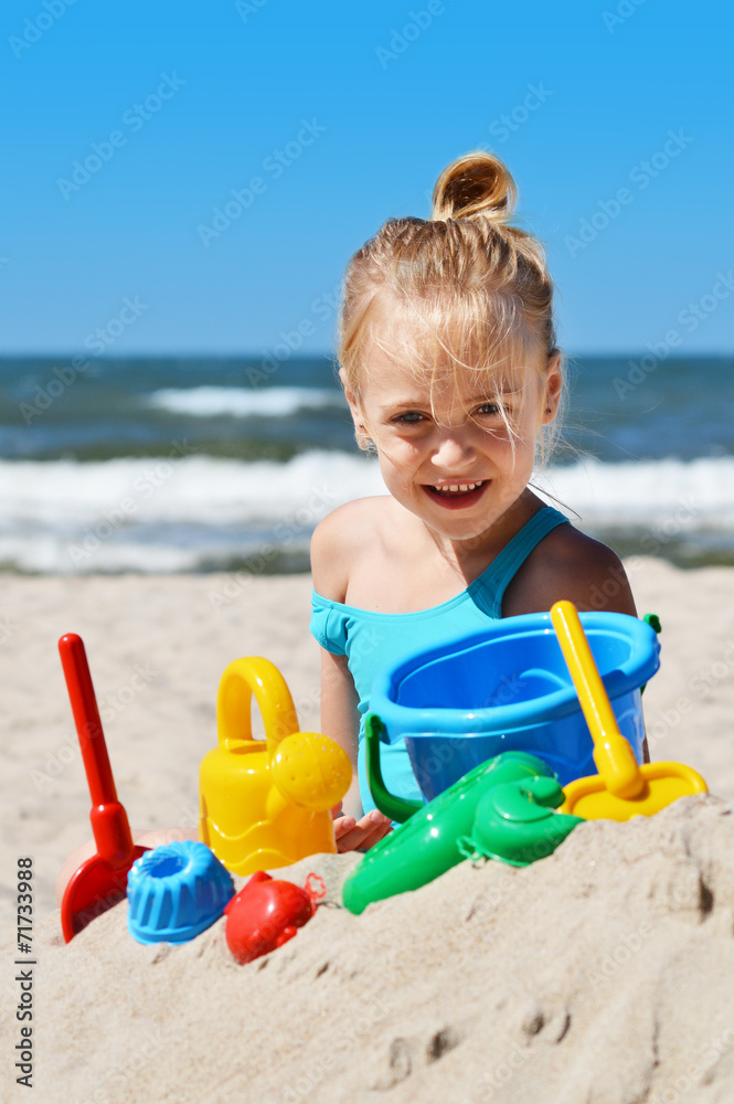 Little girl playing on the sand beach Little girl playing on the sand beach
