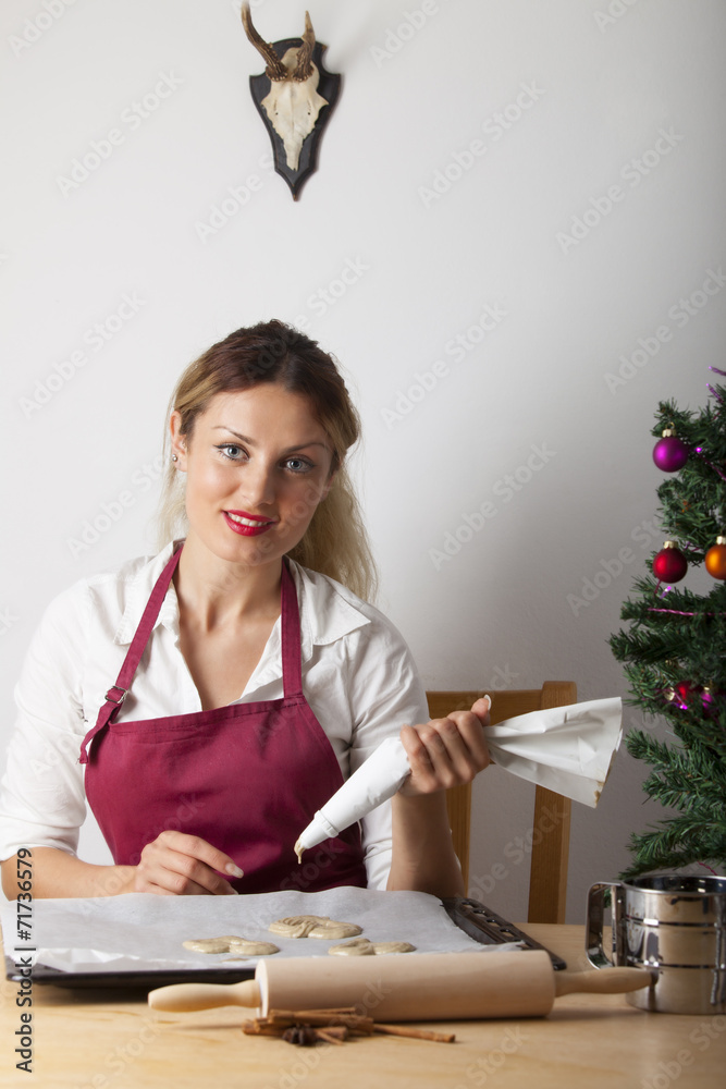Frau beim Backen mit einem Weihnachtsbaum Frau beim Backen mit einem Weihnachtsbaum