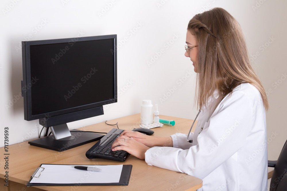 young woman doctor using computer in office young woman doctor using computer in office