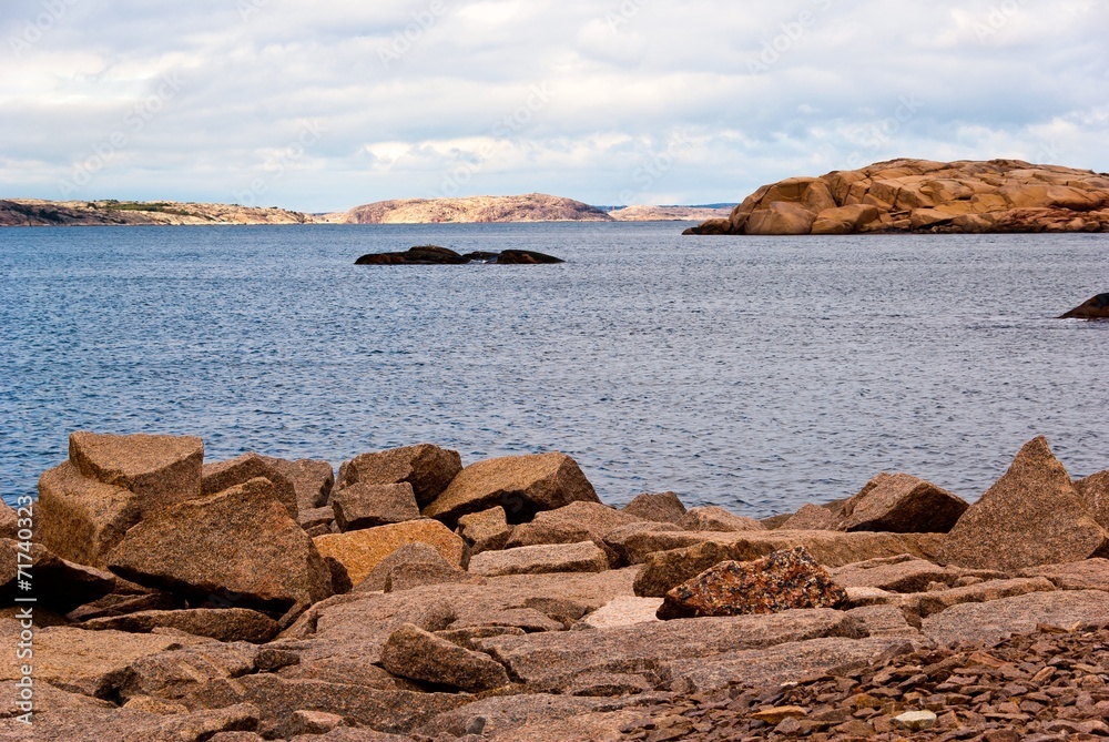 Landscape with ocean and red granite boulders.
