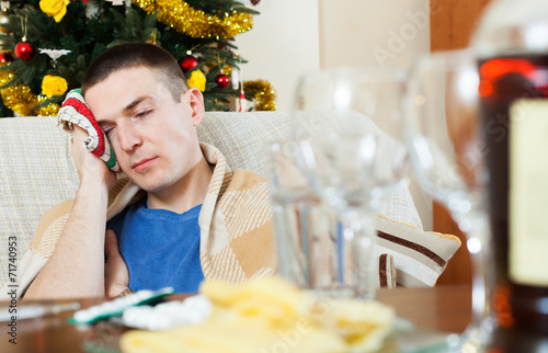 Guy having hangover after celebrating New year photo