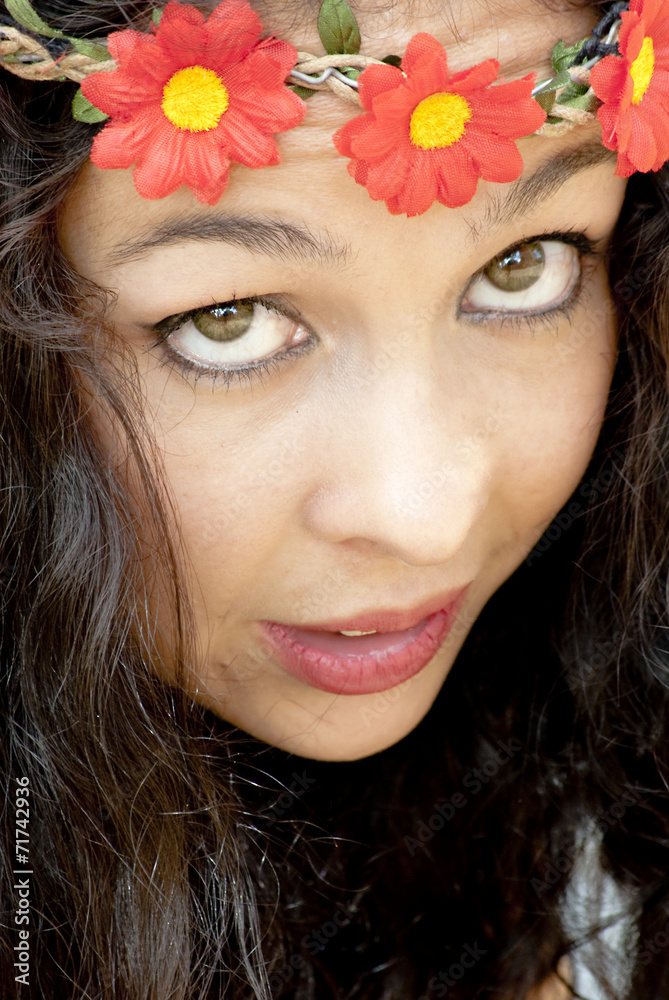 Naklejka premium Beautiful woman with a wreath of red flowers on her head in a pa